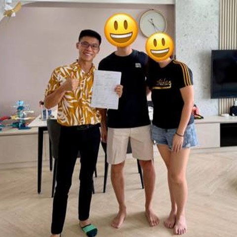 Wilfred with the family in their new living room, agreement in hand